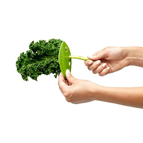 Hands using a green leaf stripper tool on kale.