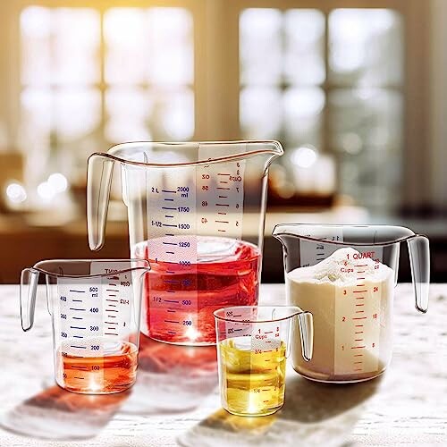 Set of measuring cups with various liquid and dry ingredients on a kitchen counter.