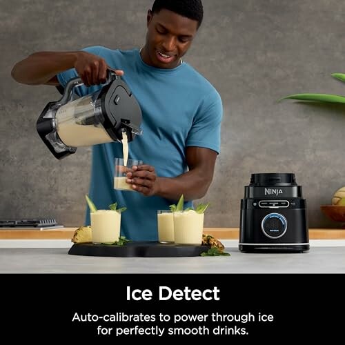 Man pouring smoothie from a blender into glasses with blender machine on counter.