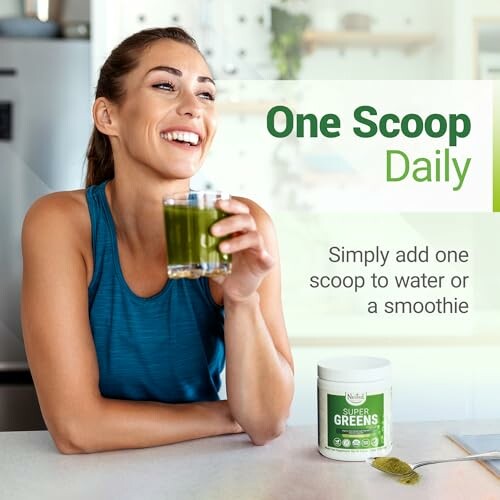 Woman enjoying a green drink with a Super Greens container on the counter.